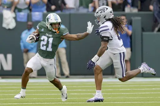 Tulane running back Makhi Hughes (21) runs against Kansas State safety Jordan Riley (6) during the first half of an NCAA college football game in New Orleans, Saturday, Sept. 7, 2024. (AP Photo/Matthew Hinton)