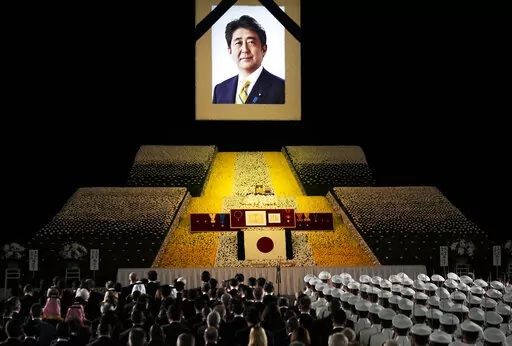 A portrait of former Japanese Prime Minister Shinzo Abe hangs on the stage during his state funeral, Tuesday, Sept. 27, 2022, Tokyo. Abe was assassinated in July. (Franck Robichon/Pool Photo via AP)