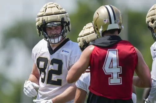 New Orleans Saints tight end Foster Moreau (82) talks with quarterback Derek Carr (4) during NFL football practice in Metairie, La., Tuesday, May 23, 2023. (AP Photo/Gerald Herbert)