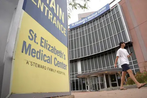 A passer-by walks past an entrance to St. Elizabeth's Medical Center, Thursday, Sept. 19, 2024, in the Brighton neighborhood of Boston. (AP Photo/Steven Senne)