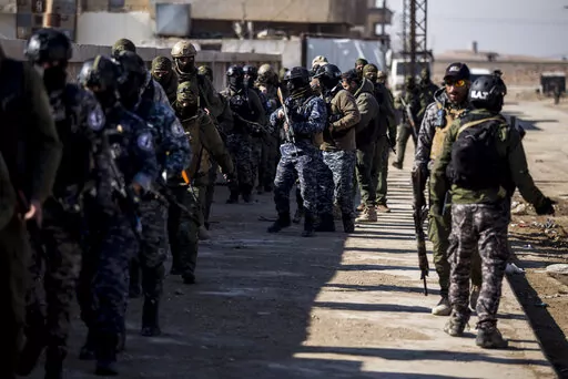 US backed Syrian Democratic Forces soldiers search for Islamic State militants in Hassakeh, Syria, Friday, Jan. 28, 2022. Friday's search came as U.S.-backed fighters set a deadline for dozens of armed extremists who remained holed up in a small part of the jail to surrender or face an all-out attack. (AP Photo/Baderkhan Ahmad)