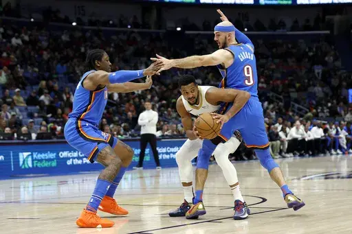 New Orleans Pelicans guard CJ McCollum (3) looks to pass between Oklahoma City Thunder forward Jalen Williams (8) and guard Alex Caruso (9) in the first half of an NBA basketball game in New Orleans, Saturday, Dec. 7, 2024. (AP Photo/Tyler Kaufman)