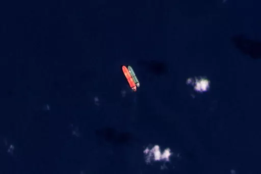 In this satellite photo provided by Planet Labs PBC, vessels identified as the Virgo, left, and the Suez Rajan, by the advocacy group United Against Nuclear Iran, are seen in the South China Sea on Feb. 13, 2022. A Greek shipper has pleaded guilty to a charge over it smuggling sanctioned Iranian crude oil and agreed to pay a $2.4 million fine, U.S. federal court papers seen Thursday, Sept. 7, 2023 by The Associated Press show. (Planet Labs PBC via AP, File)