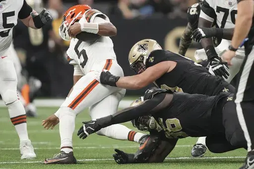 Cleveland Browns quarterback Jameis Winston (5) is sacked by New Orleans Saints defensive end Carl Granderson (96) and defensive tackle Bryan Bresee, right, in the first half of an NFL football game in New Orleans, Sunday, Nov. 17, 2024. (AP Photo/Gerald Herbert)