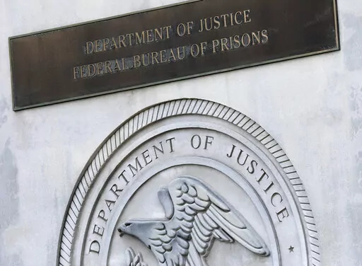 A sign for the Department of Justice Federal Bureau of Prisons is displayed at the Metropolitan Detention Center in the Brooklyn borough of New York, July 6, 2020. Oklahoma is suing the Federal Bureau of Prisons for custody of a state death row inmate who the bureau is refusing to transfer, with the state saying the man's scheduled execution cannot be carried out in December if he is not returned soon. (AP Photo/Mark Lennihan, File)