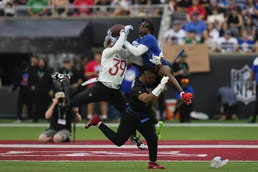 NFC wide receiver Malik Nabers, of the New York Giants, right, catches a pass while defended by AFC safety Minkah Fitzpatrick (39), of the Pittsburgh Steelers, during the flag football event at the NFL Pro Bowl, Sunday, Feb. 2, 2025, in Orlando. (AP Photo/Chris O'Meara)