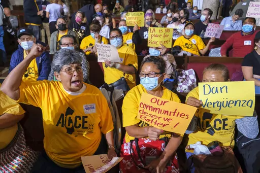 People hold signs and shout slogans before the starting the Los Angeles City Council meeting on Tuesday, Oct. 11, 2022 in Los Angeles. Cross-cultural coalitions have ruled Los Angeles politics for decades, helping elect both Black and Latino politicians to top leadership roles in the racially and ethnically diverse second largest city in America. But the year old recording of racist comments by the city's City Council president has laid bare the tensions over political power that have long quiet