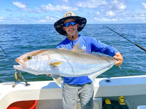 In this photo taken by Louisiana State University assistant professor Michael Dance, Capt. Brett Falterman, of Fish Research Support, displays an externally tagged greater amberjack before releasing the fish off the coast of  Venice, La., on June 9, 2022. Scientists working to get a better estimate of greater amberjack populations are tagging 750 fish to be released from Texas to North Carolina and offering $250 rewards for information and the tags. (Michael Dance/Louisiana State University via 