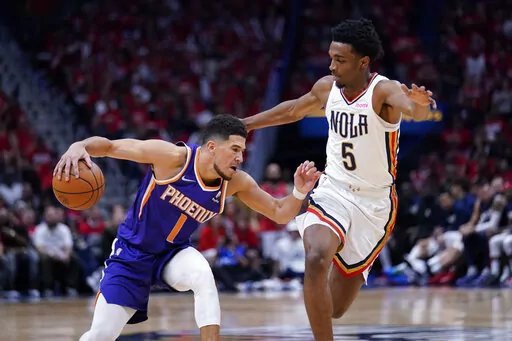 Phoenix Suns guard Devin Booker (1) drives to the basket against New Orleans Pelicans forward Herbert Jones (5) in the second half of Game 6 of an NBA basketball first-round playoff series, Thursday, April 28, 2022 in New Orleans. The Suns won 115-109, to win the series 4-2 and advance to the second-round. (AP Photo/Gerald Herbert)