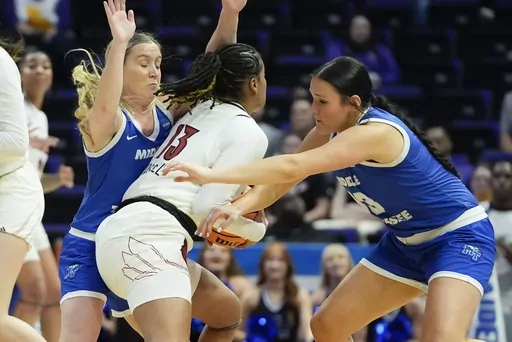 Middle Tennessee guard Savannah Wheeler and forward Courtney Whitson, right, trap Louisville guard Merissah Russell (13) during the first half of a first-round college basketball game in the women's NCAA Tournament in Baton Rouge, La., Friday, March 22, 2024. (AP Photo/Gerald Herbert)