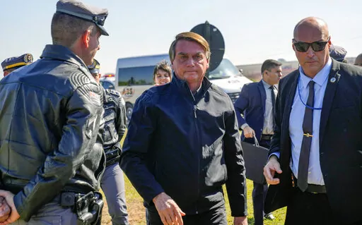 Brazilian President Jair Bolsonaro arrives to a resort hotel where he is expected to meet with Elon Musk in Porto Feliz, Brazil, Friday, May 20, 2022. The Telsa and SpaceX chief executive officer tweeted that he was in Brazil to help bring Internet service to rural schools in the Amazon and to help monitor the Amazon environmentally. (AP Photo/Andre Penner)