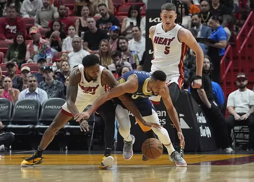 New Orleans Pelicans guard CJ McCollum (3) and Miami Heat forward Haywood Highsmith (24) go after a loose ball during the first half of an NBA basketball game, Friday, March 22, 2024, in Miami. (AP Photo/Marta Lavandier)