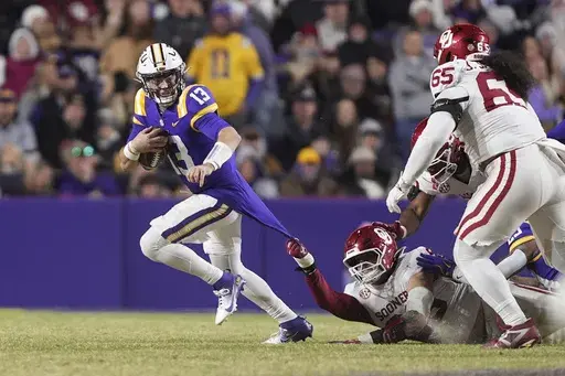 Oklahoma linebacker Danny Stutsman pulls the jersey of LSU quarterback Garrett Nussmeier (13) as he scrambles in the second half an NCAA college football game in Baton Rouge, La., Saturday, Nov. 30, 2024. LSU won 37-17. (AP Photo/Gerald Herbert)
