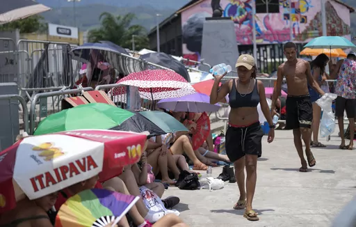 Street vendors sell bottled water to Taylor Swift fans amid a heat wave before her Eras Tour concert outside the Nilton Santos Olympic stadium in Rio de Janeiro, Brazil, Saturday, Nov. 18, 2023. A 23-year-old Taylor Swift fan died at the singer's Eras Tour concert in Rio de Janeiro Friday night, according to a statement from the show's organizers in Brazil. Both Swifties and politicians reacted to the news with outrage. While a cause of death for Ana Clara Benevides Machado has not been announce