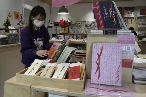 A worker arranges books at a bookstore specializing in nüshu, a centuries-old secret script, in Chengdu in southwestern China's Sichuan province, March 17, 2024. (AP Photo/Ng Han Guan)