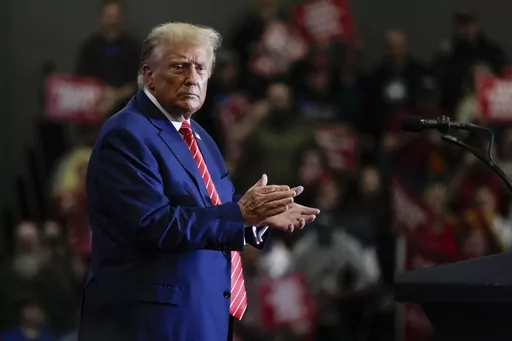Republican presidential candidate former President Donald Trump stands on stage after speaking during a commit to caucus rally, Saturday, Jan. 6, 2024, in Clinton, Iowa. (AP Photo/Charlie Neibergall)