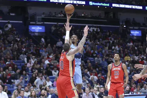 Memphis Grizzlies guard Ja Morant, center top, shoots a floater over New Orleans Pelicans center Daniel Theis (10) in the first half of an NBA basketball game in New Orleans, Friday, Dec. 27, 2024. (AP Photo/Peter Forest)
