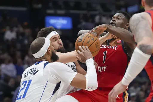 New Orleans Pelicans forward Zion Williamson (1) is fouled as he drives to the basket against Dallas Mavericks center Daniel Gafford (21) and guard Klay Thompson in the first half of an NBA basketball game in New Orleans, Wednesday, Jan. 29, 2025. (AP Photo/Gerald Herbert)