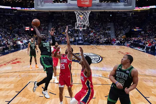 Boston Celtics guard Jaylen Brown (7) shoots over New Orleans Pelicans guard Trey Murphy III (25) and forward Herbert Jones in the first half of an NBA basketball game in New Orleans, Friday, Nov. 18, 2022. The Celtics won 117-109. (AP Photo/Gerald Herbert)
