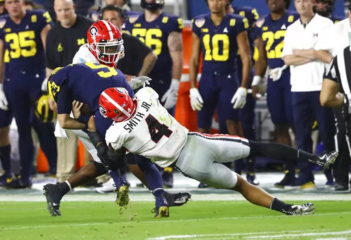 Georgia linebacker Nolan Smith (4) tackles Michigan quarterback J.J. McCarthy (9) during the second quarter of the NCAA College Football Playoff Orange Bowl game Friday, Dec. 31, 2021, in Miami Gardens, Fla.  Georgia will play Alabama in an all-Southeastern Conference College Football Playoff national championship on Monday, Jan. 10, 2022.  (Curtis Compton/Atlanta Journal-Constitution via AP, File)