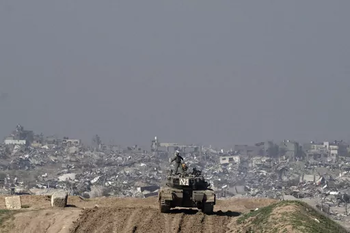 Israeli soldiers overlook the Gaza Strip from a tank, as seen from southern Israel, Friday, Jan. 19, 2024. (AP Photo/Maya Alleruzzo)