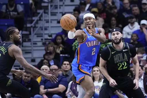 Oklahoma City Thunder guard Shai Gilgeous-Alexander (2) passes between Oklahoma City Thunder guard Cason Wallace (22) and forward Naji Marshall (8) in the first half of an NBA basketball game in New Orleans, Friday, Jan. 26, 2024. (AP Photo/Gerald Herbert)