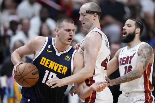 Denver Nuggets center Nikola Jokic (15) dribbles around Miami Heat center Cody Zeller (44) during the first half of Game 4 of the basketball NBA Finals, Friday, June 9, 2023, in Miami. (AP Photo/Wilfredo Lee)