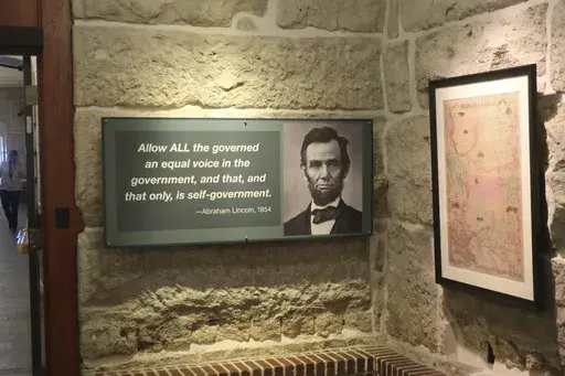 A historical exhibit at the Kansas Statehouse includes a display quoting President Abraham Lincoln next to a map showing the original extent of the Kansas-Nebraska territories before Kansas became a state and Lincoln took office in 1861, Thursday, Feb. 13, 2025, in Topeka, Kansas. (AP Photo/John Hanna)