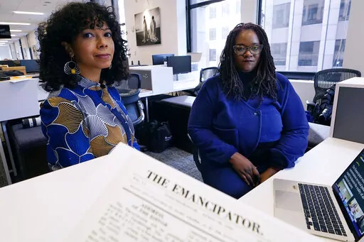 Amber Payne, left, and Deborah Douglas co-editors-in-chief of the new online publication of "The Emancipator" pose at their office inside the Boston Globe, Wednesday, Feb. 2, 2022, in Boston. Boston University's Center for Antiracist Research and The Boston Globe's Opinion team are collaborating to resurrect and reimagine The Emancipator, the first abolitionist newspaper in the United States, which was founded more than 200 years ago. The new incarnation of The Emancipator will explore ways to r