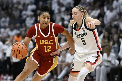 Southern California guard JuJu Watkins (12) is guarded by UConn guard Paige Bueckers (5) in the second half of an NCAA college basketball game, Saturday, Dec. 21, 2024, in Hartford, Conn. (AP Photo/Jessica Hill)