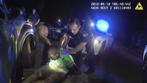 This image from the body camera of Louisiana State Police Trooper Dakota DeMoss shows his colleagues, Kory York, center left, and Chris Hollingsworth, center right, holding up Ronald Greene before paramedics arrived on May 10, 2019, outside of Monroe, La. (Louisiana State Police via AP, File)