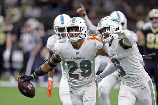 Miami Dolphins safety Brandon Jones (29) celebrates with Jevon Holland (8) after intercepting a pass against the New Orleans Saints during the second half of an NFL football game Monday, Dec. 27, 2021, in New Orleans. The Dolphins won 20-3. (AP Photo/Butch Dill)