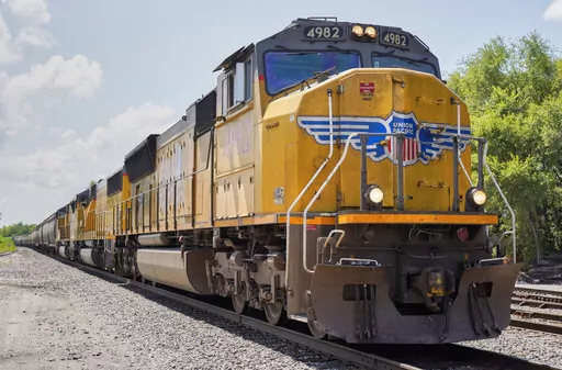 In this July 31, 2018, file photo a Union Pacific train travels through Union, Neb. Union Pacific's first-quarter profit declined 9% as the railroad delivered less freight and its revenue fell. A major fertilizer company says the limits Union Pacific is putting on rail traffic to clear up congestion will delay shipments that farmers need during the spring planting season. (AP Photo/Nati Harnik, File)