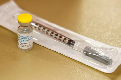 A vial containing the monkeypox vaccine and a syringe is set on the table at a vaccination clinic run by the Mecklenburg County Public Health Department in Charlotte, N.C., Saturday, Aug. 20, 2022. At-risk people who received just one dose of the monkeypox vaccine appeared to be significantly less likely to get sick from the virus, public health officials announced Wednesday, even as they urged a second dose for full protection. (AP Photo/Nell Redmond, File)