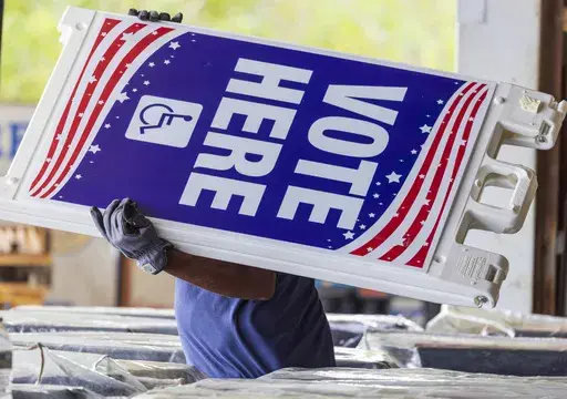 Voting machines and signs are loaded onto trucks from a warehouse in New Orleans East for delivery across the parish on Monday, Nov. 4, 2024, the day before the presidential election. (Chris Granger/The Times-Picayune/The New Orleans Advocate via AP)