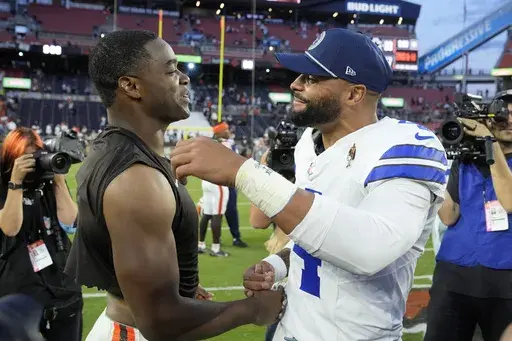 Cleveland Browns' Amari Cooper, left, and Dallas Cowboys' Dak Prescott, right, greet each other after their team's NFL football game in Cleveland, Sunday, Sept. 8, 2024. (AP Photo/Sue Ogrocki)