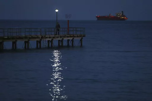 A man walks on a dock as a ship seen in the background in southern port city of Limassol, Cyprus, Friday, Feb. 23, 2018. Cyprus is working out with partners in the European Union and the Middle East the logistics to establish a sea corridor to deliver a stream of vital humanitarian aid to Gaza from the island’s main port of Limassol once the situation on the ground permits it. (AP Photo/Petros Karadjias, File)