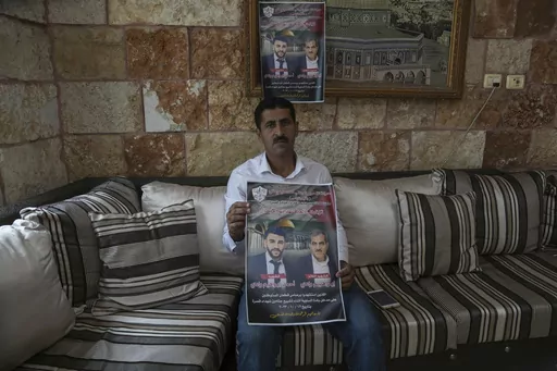 Abdelazim Wadi, 50, holds up a poster commemorating his brother, Ibrahim Wadi, and his nephew, Ahmed Wadi, who were killed by Israeli settlers during a funeral procession on Oct. 12 in the rural Palestinian village of Qusra, West Bank, Sunday, Nov. 12, 2023. With the world’s attention focused on the fighting in Gaza, Israeli settler violence against Palestinians since Oct. 7 has surged to the highest levels ever recorded by the United Nations. Palestinians say this Israel-Hamas war has left th