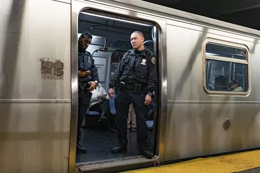 NYPD officers stand aboard a train at the West Fourth Street subway station, Saturday, Jan. 13, 2024, in New York. Prosecutors say a man who shot and critically wounded another man on a New York City subway train will not immediately be charged with a crime while prosecutors investigate whether the shooter acted justifiably in self-defense.(AP Photo/Peter K. Afriyie, File)