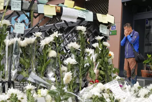 A man weeps as he pays tribute to victims of a deadly accident following Saturday night's Halloween festivities on a street near the scene in Seoul, South Korea, Tuesday, Nov. 1, 2022.  South Korean police investigated on Monday what caused a crowd surge that killed more than 150 people during Halloween festivities in Seoul in the country’s worst disaster in years. (AP Photo/Ahn Young-joon)