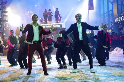 This image released by Apple TV+ shows Ryan Reynolds, left, and Will Ferrell in a scene from "Spirited." (Claire Folger/Apple TV+ via AP)