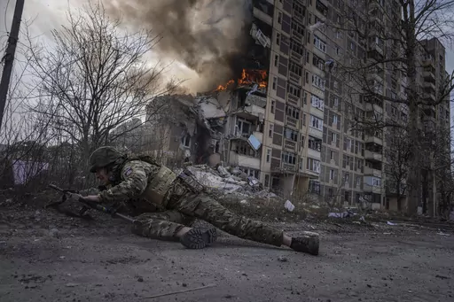 A Ukrainian police officer takes cover in front of a burning building in Avdiivka, Ukraine, Friday, March 17, 2023. The second year of Ukraine’s fight against Russia’s full-scale invasion brought no respite for Ukrainian soldiers or civilians. Associated Press photographers documented the past 12 months of death and destruction, agony and grief — as well as the glimpses of joy — that are staples of life during war. (AP Photo/Evgeniy Maloletka)