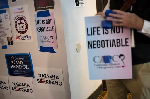 An Anti-abortion supporter holds a sign at the California Republican Party Convention in Anaheim, Calif., Sept. 30, 2023. In a new twist to the abortion debate, congressional Republicans are trying to block a Biden administration spending rule that they say will cut off millions of dollars to anti-abortion counseling centers. The rule would prohibit states from sending federal funds earmarked for needy Americans to so-called "crisis pregnancy centers," which counsel against abortions.(AP Photo/J