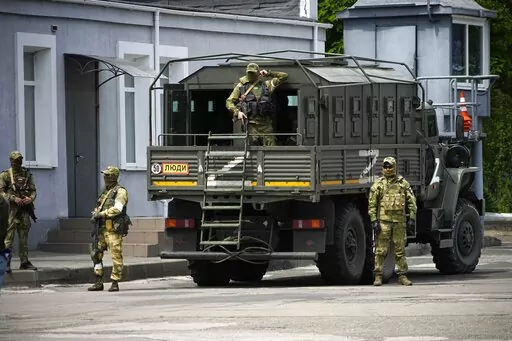 Russian soldiers guard an area as a group of foreign journalists visit in Kherson, Kherson region, south Ukraine, May 20, 2022. The southern city of Kherson was the first to fall to Russia's invasion. But Kherson remains at the heart of the conflict and Ukraine's efforts to save its vital access to the sea. (AP Photo, File)