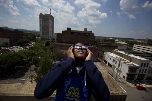 Justin Coleman, of Birmingham, Ala., holds his glasses up to his eyes as he watches the solar eclipse atop a parking structure, Monday, Aug. 21, 2017, in Birmingham. Safe solar eclipse glasses block out the sun’s ultraviolet rays and nearly all visible light. When worn indoors, only very bright lights should be faintly visible – not household furniture or wallpaper. (AP Photo/Brynn Anderson, File)