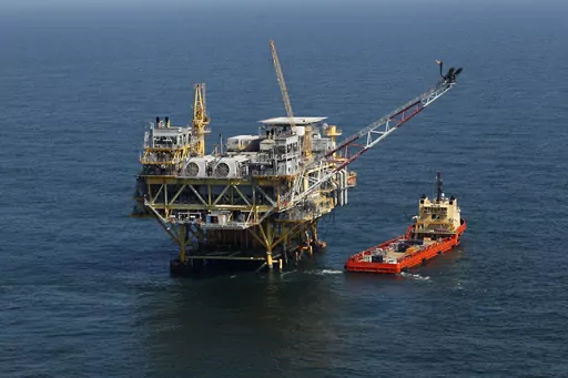 A rig and supply vessel are pictured in the Gulf of Mexico off the cost of Louisiana, April 10, 2011. A federal judge has ordered the Interior Department to expand next week’s scheduled sale of Gulf of Mexico oil and gas leases by millions of acres. The Thursday, Sept. 22, 2023, ruling rejected a scaled-back plan announced last month by the Biden administration as part of an effort to protect an endangered whale species. (AP Photo/Gerald Herbert, File)