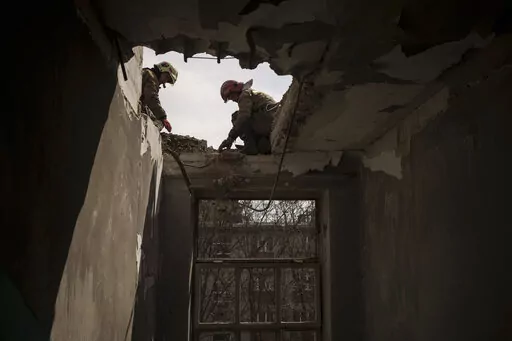 Firefighters work to secure a building previously damaged by a Russian attack in Kharkiv, Ukraine, Saturday, April 9, 2022. (AP Photo/Felipe Dana)