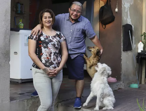 Fabricio Chicas, a transgender man, right, poses for a photo with his partner Elizabeth Lopez, and their pets, at their home in San Salvador, El Salvador, Sunday, April 30, 2023. Even though the country’s Supreme Court in 2022 determined that the inability of a person to change their name because of gender identity constitutes discriminatory treatment, the 49-year-old has not been able to change his name from Patricia to Fabricio, nor his gender on his ID, a fate shared by many transgender peo
