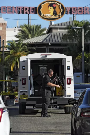 A Tampa police officer opens a tripod in the Ybor City section of Tampa, Fla., after a shooting early Sunday, Oct. 29, 2023. A fight between two groups turned deadly in a shooting during Halloween festivities. (AP Photo/Chris O'Meara)