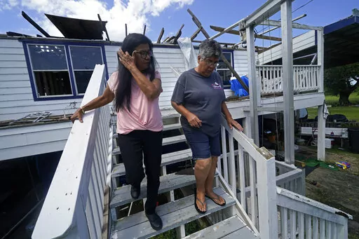 Louise Billiot, left, a member of the United Houma Nation Indian tribe, walks around the home of her friend and tribal member Irene Verdin, which was heavily damaged from Hurricane Ida nine months before, along Bayou Pointe-au-Chien, in Pointe-aux-Chenes, La., on May 26, 2022. The Federal Emergency Management Agency has developed a singular plan to engage more fully with hundreds of Native American tribes who continue to face climate change-related disasters, the agency announced Thursday, Aug. 